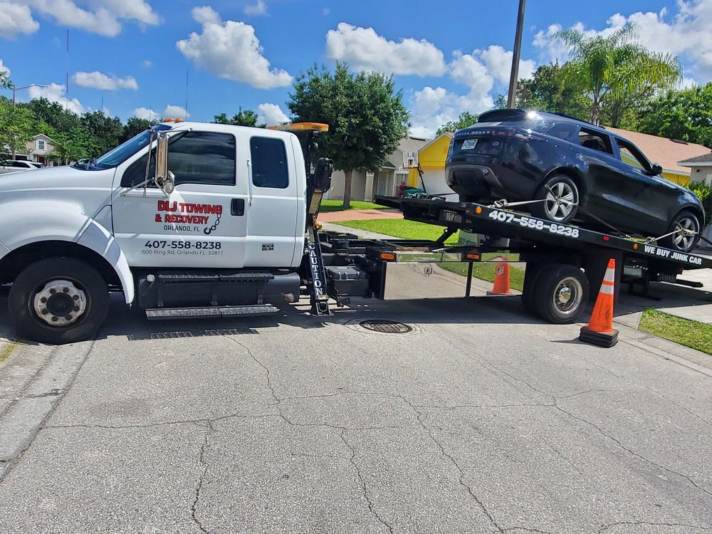 DLJ Towing flatbed carrying a Range Rover in an Orlando neighborhood