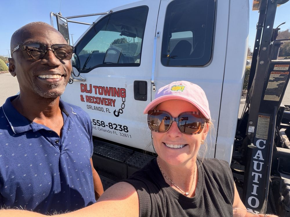 Danny, owner of DLJ Towing, with a happy customer in front of the DLJ Towing truck in Orlando